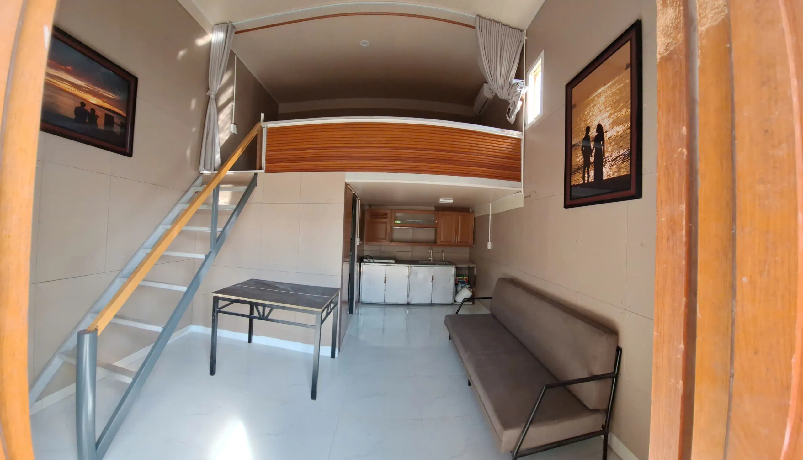 Phòng khách gác lửng, sofa, bàn và bếp phía dưới